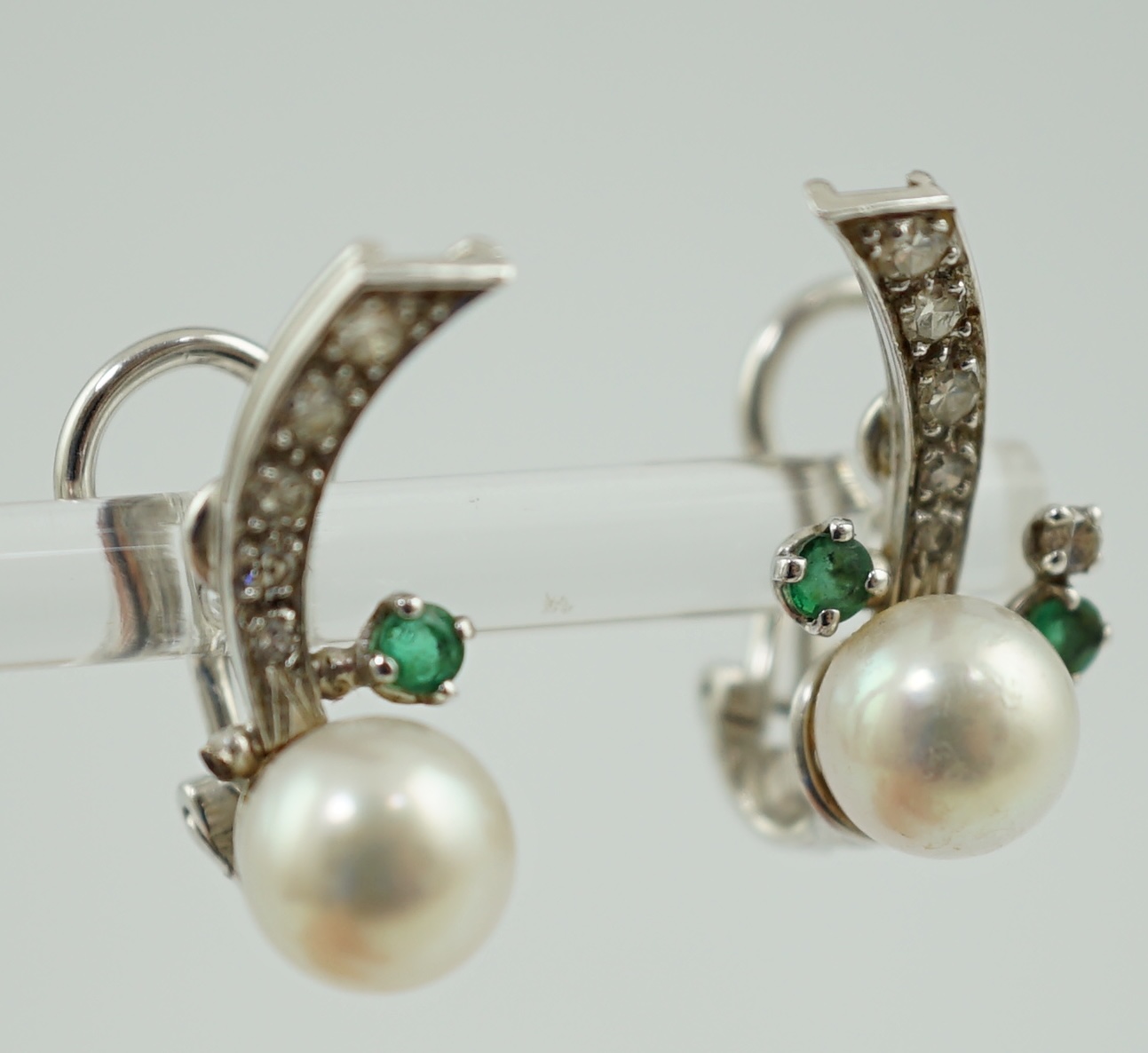 A modern pair of white gold, cultured pearl, emerald and diamond cluster set ear studs